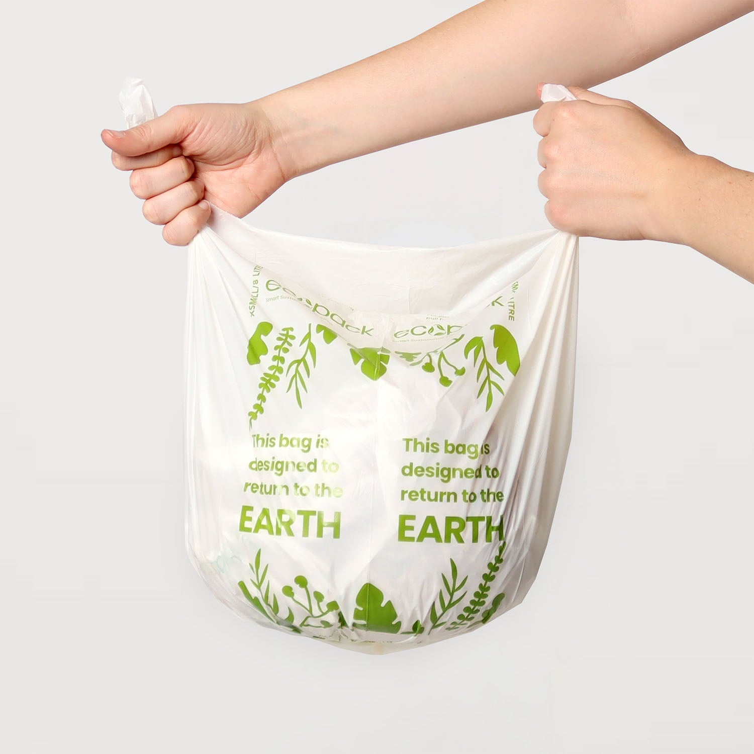 Hand holding a 8L compostable bin liner to show size